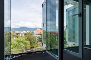 an open window with a view of a city at Nidhra Lanna Hotel Chiang Mai in Chiang Mai