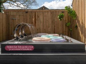 a water fountain with a bunch of plates in it at Gorgeous Stylish Home Near Longleat and Bath with Private Heated Pool and Sauna in Corsley