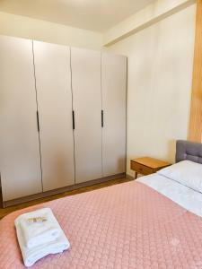 a bedroom with white cabinets and a bed with a pink rug at Rosette Rose AC Progres in Toruń