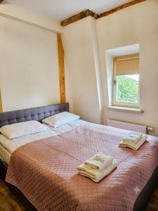 a bedroom with a bed with two towels on it at Rosette Rose AC Progres in Toruń +4 photos