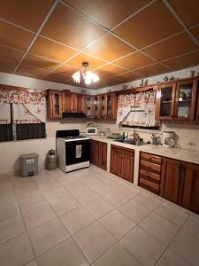 a kitchen with wooden cabinets and a stove at Comfortable 3-bedroom, 1-kitchen cottage in Cerro Punta