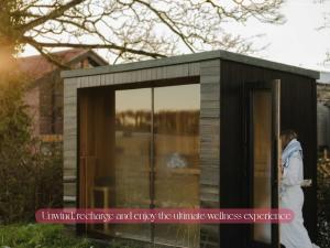 a woman walking in front of a tiny house at Gorgeous Stylish Home Near Longleat and Bath with Private Heated Pool and Sauna in Corsley