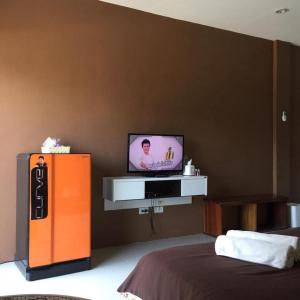 a room with a tv on a wall with a bed at Ratchanee Place in Chaiyaphum +29 photos