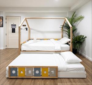 two beds in a bedroom with a headboard at Nidhra Lanna Hotel Chiang Mai in Chiang Mai