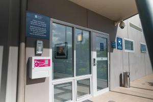 an entrance to a building with a cell phone dispenser at MainStay Suites Whyalla in Whyalla