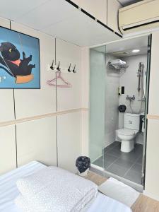 a bathroom with a glass shower and a toilet at K & B Hostel in Hong Kong
