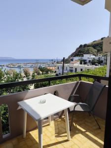 a white table and a chair on a balcony at Apokoros Craft Deco Apartments & Studios in Kalyves
