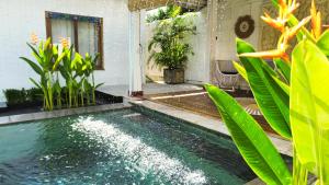 a swimming pool in a house with green plants at Empat Bintang Villas in Uluwatu