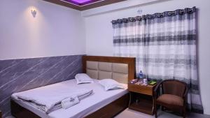 a small bedroom with a bed and a desk with a chair at Hotel Cox Rotana in Cox's Bazar