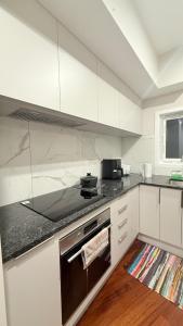 a kitchen with white cabinets and a stove top oven at Million Dollar View in Wellington