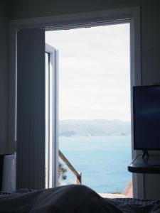 a view of the ocean from a bedroom window at Million Dollar View in Wellington +7 photos