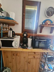 a kitchen with a microwave and a toaster oven on a counter at Barcarelles avec PISCINE Plage clim 5 personnes in Le Barcarès
