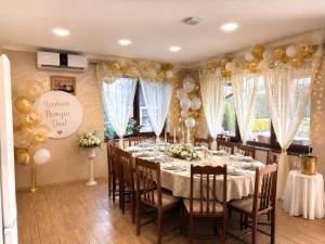 a dining room with a long table with gold balloons at Erida Guest House - къща за гости до Русе in Trastenik +87 photos