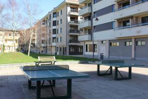 two ping pong tables and a bench in front of a building at Kantabriko Zarautz in Zarautz