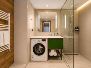 a bathroom with a washing machine under a sink at Skyline Privilege in Marriott in Batumi