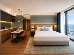 a bedroom with a bed and a kitchen with a table at Skyline Privilege in Marriott in Batumi