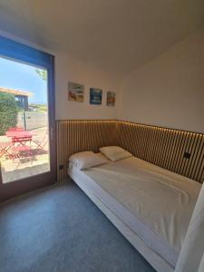 a bedroom with a bed and a balcony with a table at Barcarelles avec PISCINE Plage clim 5 personnes in Le Barcarès