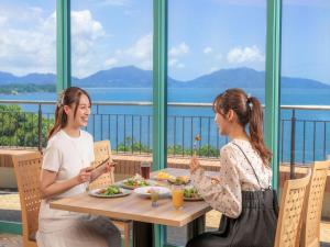 two women sitting at a table eating food at KAMENOI HOTEL Genkainada All-Inclusive Resort in Kitakyushu
