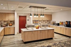 a large kitchen with wooden cabinets and a counter top at Homewood Suites by Hilton Macon-North in Wesleyan Hills