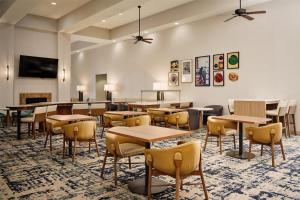 a dining room with tables and chairs and a fireplace at Homewood Suites by Hilton Macon-North in Wesleyan Hills
