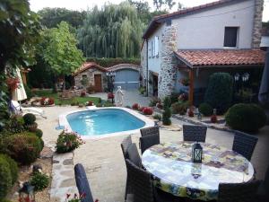 a patio with a table and a swimming pool at Le clos fleuri in Saint-Gervazy