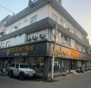 Ein weißer Lastwagen parkte vor einem Gebäude in der Unterkunft Hotel De Agya in Ludhiana