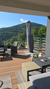 a deck with chairs and tables and a view of a mountain at Loft Apart View & Wellness in Szczyrk
