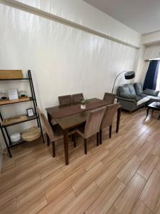 a living room with a table and chairs and a couch at JFam Suites, C1-5L 1BR , Up To 7 Pax in Biñan
