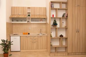 a kitchen with wooden cabinets and a sink at Apartments Matija&scaron;ević in Nik&scaron;ić