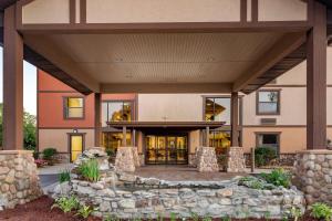 an exterior view of a building with a stone wall at Comfort Inn & Suites Branson Meadows in Branson