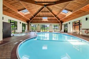 a large indoor swimming pool with a wooden ceiling at Comfort Inn & Suites Branson Meadows in Branson