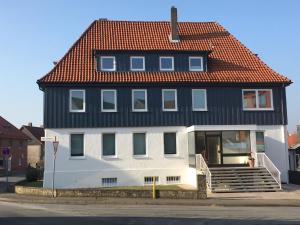 ein großes weißes Haus mit rotem Dach in der Unterkunft Design Fewo am Harz in Langelsheim