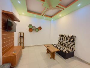 a living room with a chair and a tv at Impulse Ocean View in Cox's Bazar
