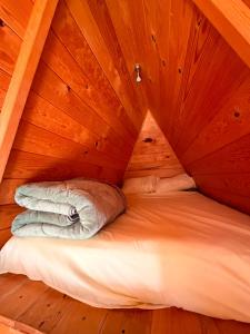 a bed in a room with a wooden ceiling at azomalli cabañas in Bernal