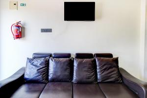 a leather couch with two pillows in a living room at Hotel O SNIST University Hyderabad Formerly Hari Hara Enterprise in Maula Ali