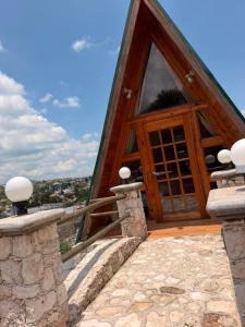a house with a wooden door and a stone walkway at azomalli cabañas in Bernal