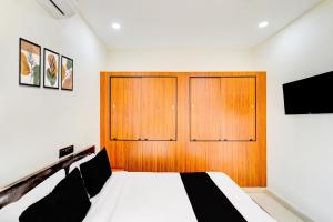 a bedroom with a bed and a wooden door at Hotel O SNIST University Hyderabad Formerly Hari Hara Enterprise in Maula Ali +28 photos