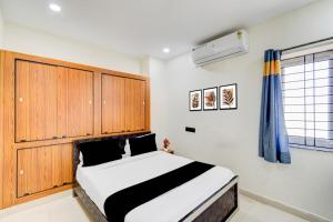 a bedroom with a bed with a wooden headboard at Hotel O SNIST University Hyderabad Formerly Hari Hara Enterprise in Maula Ali