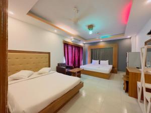 a hotel room with two beds and a window at Impulse Ocean View in Cox's Bazar