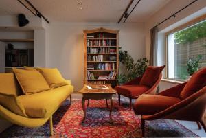 a living room with a couch and two chairs and a book shelf at Mari Pop Hotel in Ried im Zillertal