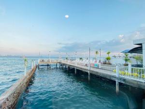 a dock in the water next to a beach at ลุงชีพบ้านพัก เกาะล้านLoongcheeb House in Ko Larn