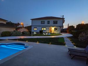 a house with a swimming pool in front of a house at Forxan in Sanxenxo