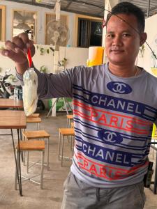 a man holding a toothbrush in a bag of food at ลุงชีพบ้านพัก เกาะล้านLoongcheeb House in Ko Larn