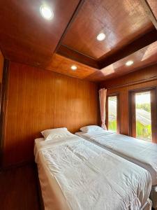 a bedroom with a large bed in a boat at Thai Style House - Yao Noi in Ko Yao Noi +5 photos