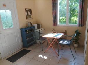 a kitchen with a table and chairs and a table and a microwave at Les 2 Chênes in Saumur