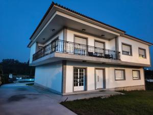 a white house with a balcony on top of it at Forxan in Sanxenxo