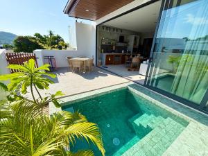 a swimming pool in front of a house at Big leaf villa cozy in Bangrak Beach