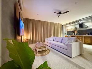 a living room with a couch and a tv at Big leaf villa cozy in Bangrak Beach