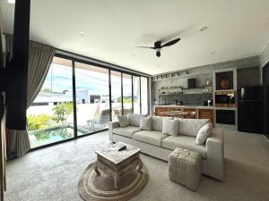 a living room with a couch and a table at Big leaf villa cozy in Bangrak Beach