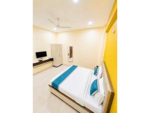 a bedroom with a bed and a tv at HOTEL MEDHYA GRAND Near Goḏawalia Chauraha - 200 Meter From Baba Vishwanath Temple & Ganga Arti Ghat ! Wi-Fi #Lift #Hygiene & Spacious Room - BEST HOTEL IN VARANASI in Varanasi